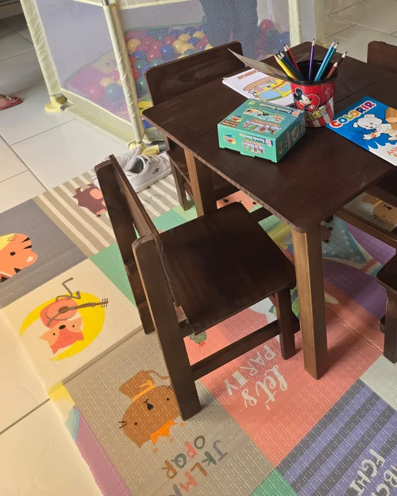 Área kids com mesinha, cadeiras e tapete colorido