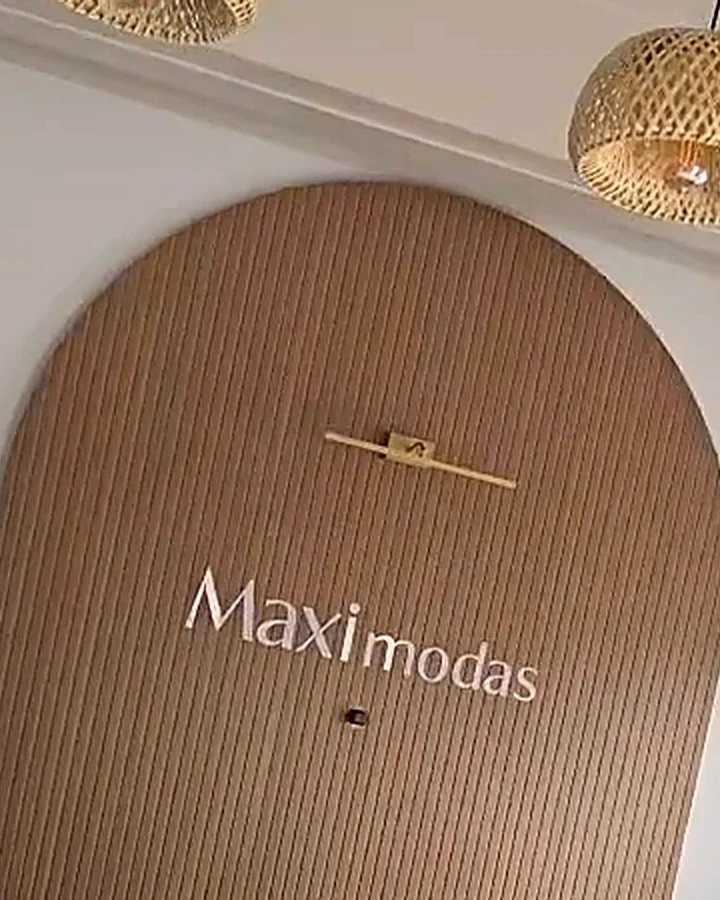 Balcão de entrada com painel de madeira e o logo da loja